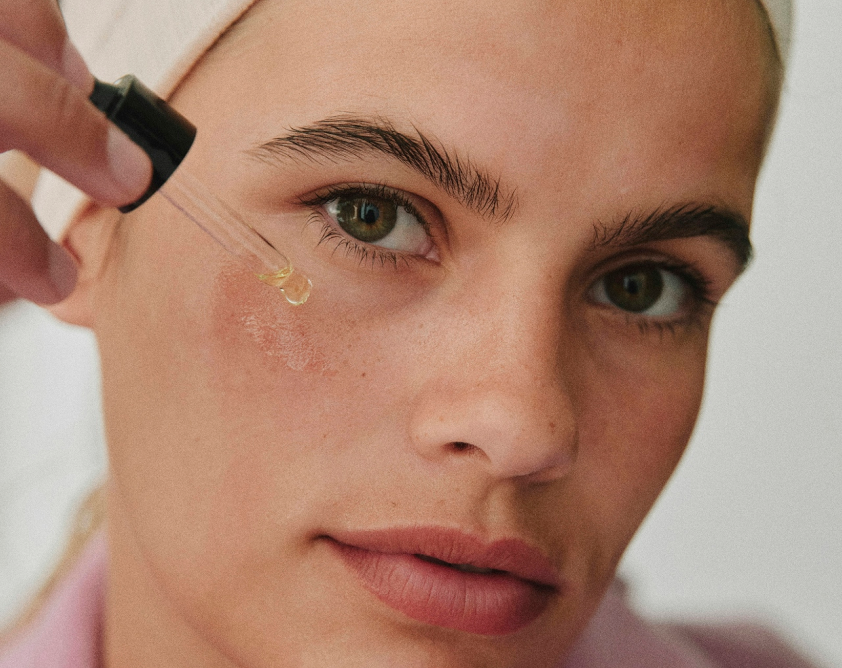 Concentré à la Rose Noire Sisley serum with pink texture applied on skin