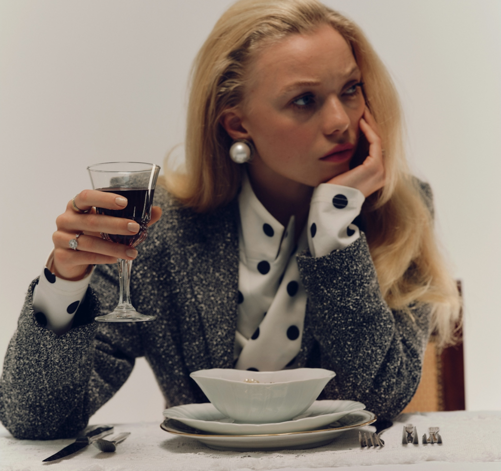 Una mujer sostiene una copa en silencio, evocando el holiday blues y las emociones que no siempre coinciden con la temporada festiva.